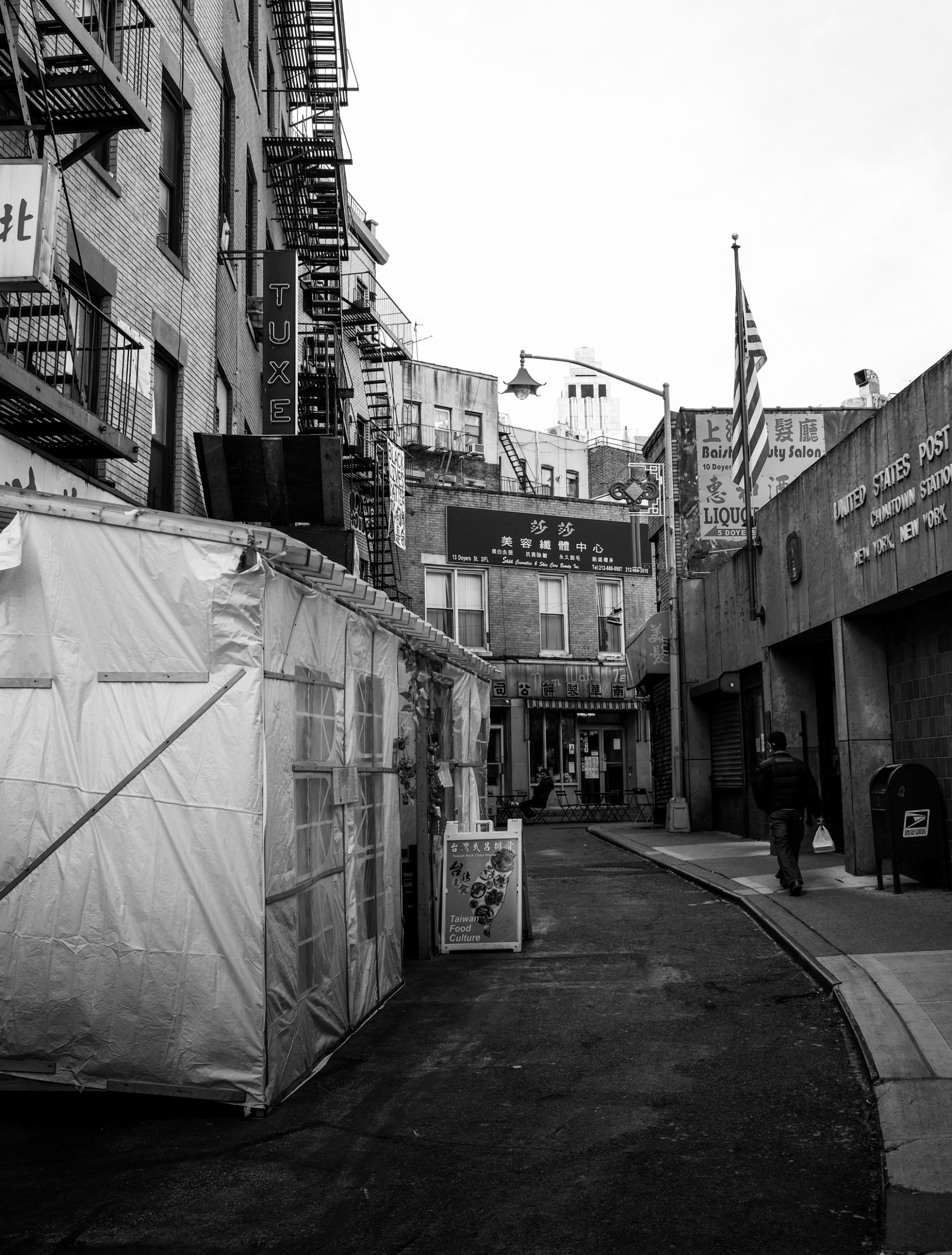 Black-and-white photograph of a street in Chinatown in NYC.