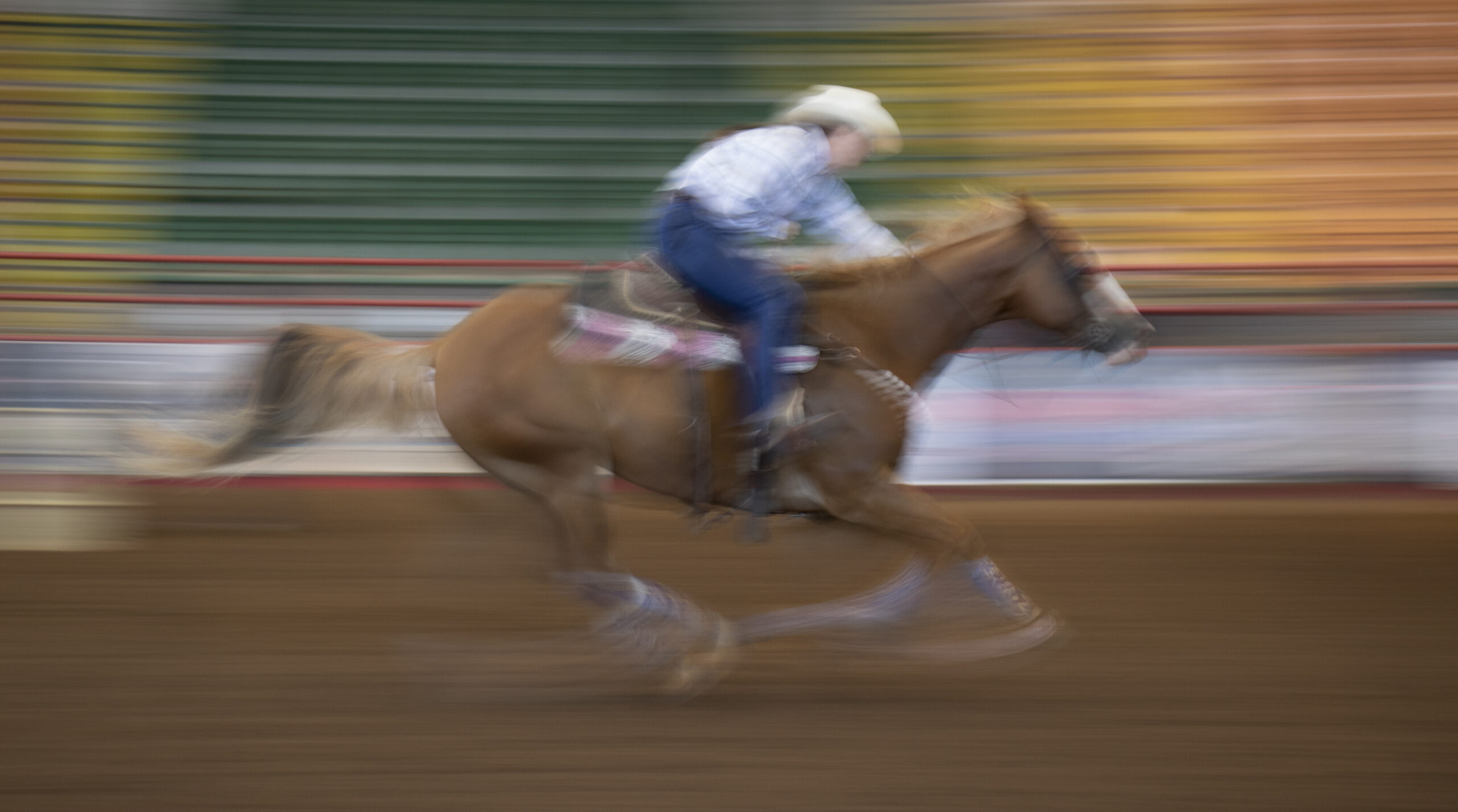 A motion-blurred image of a barrel racer finishing a race